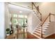 Grand foyer with staircase and view into the living room with large windows at 9136 Palm Bay Cir, Raleigh, NC 27617
