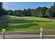 Scenic view of the meticulously maintained golf course, surrounded by trees, under a clear sky at 9136 Palm Bay Cir, Raleigh, NC 27617