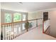 Carpeted upstairs hallway overlooking the living room with tall windows at 9136 Palm Bay Cir, Raleigh, NC 27617