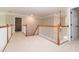 Carpeted upstairs hallway with white railings and wooden trim leading to the staircase at 9136 Palm Bay Cir, Raleigh, NC 27617
