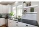 Bright kitchen featuring white cabinets, stainless steel appliances, granite counters, and decorative shelving at 9136 Palm Bay Cir, Raleigh, NC 27617