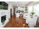 Open-concept living room flows into the kitchen with fireplace, white chairs, hardwood floors and tv at 9136 Palm Bay Cir, Raleigh, NC 27617