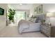 Main bedroom featuring a large window, neutral carpet, a ceiling fan and bedside lamps at 9136 Palm Bay Cir, Raleigh, NC 27617