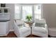 Cozy sitting area with white armchairs, and a bay window with a lush green plant at 9136 Palm Bay Cir, Raleigh, NC 27617
