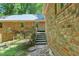 Brick home exterior with steps and walkway surrounded by lush greenery at 9257 Sauls Rd, Raleigh, NC 27603