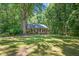 Charming brick home with a cozy front porch surrounded by mature trees and a lush green lawn at 9257 Sauls Rd, Raleigh, NC 27603