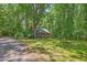 Secluded brick home featuring a welcoming front porch and lush landscaping at 9257 Sauls Rd, Raleigh, NC 27603