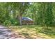 Charming brick home with a cozy front porch surrounded by mature trees and a lush green lawn at 9257 Sauls Rd, Raleigh, NC 27603
