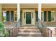 Charming covered porch with brick steps and decorative columns, offering a warm welcome at 9257 Sauls Rd, Raleigh, NC 27603