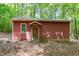 Exterior view of a small outbuilding on a wooded lot at 9257 Sauls Rd, Raleigh, NC 27603