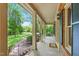 Relaxing covered porch with patterned flooring, white columns, and scenic views of the lush yard at 9257 Sauls Rd, Raleigh, NC 27603
