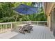 Backyard deck with white railing, umbrella-covered outdoor dining table, and surrounding wooded area at 9507 Sertoma Rd, Chapel Hill, NC 27516
