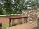 Back porch featuring wooden railing and natural stone siding with a view of a grassy lawn at 95113 Vance Knls, Chapel Hill, NC 27517