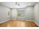A bright bedroom featuring wood floors, plantation shutters, ceiling fan, and neutral paint at 95113 Vance Knls, Chapel Hill, NC 27517