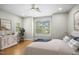 A bright bedroom featuring wood floors, plantation shutters, ceiling fan, and neutral paint at 95113 Vance Knls, Chapel Hill, NC 27517