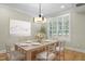 Staged dining room with hardwood floors, plantation shutters, and modern chandelier at 95113 Vance Knls, Chapel Hill, NC 27517