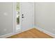 Clean, minimalist entryway with hardwood floors, white door and trim at 95113 Vance Knls, Chapel Hill, NC 27517