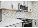 Close up of stainless steel microwave and stove set against a decorative backsplash at 95113 Vance Knls, Chapel Hill, NC 27517