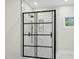 Beautifully tiled shower with sleek, dark hardware and a glass enclosure in the modern primary bath at 95113 Vance Knls, Chapel Hill, NC 27517