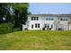 A view of the backyard with a lawn that leads up to the back of a two-story home at 97 Begonia St, Angier, NC 27501
