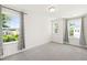 Bright, carpeted bedroom featuring large windows with patterned curtains and scenic views at 97 Begonia St, Angier, NC 27501