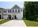 Charming townhome featuring a one-car garage and inviting curb appeal with green lawn at 97 Begonia St, Angier, NC 27501