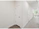 Hallway features neutral carpet, a door, and views to a staircase and window at 97 Begonia St, Angier, NC 27501