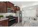 Kitchen with stainless steel appliances, granite countertops, and wood-style floors at 97 Begonia St, Angier, NC 27501