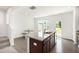 Open kitchen area with granite island, stainless steel sink, and wood-style floors at 97 Begonia St, Angier, NC 27501
