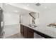 Kitchen island with stainless steel sink, granite countertops, and wood-style floors at 97 Begonia St, Angier, NC 27501
