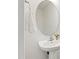 Cozy powder room featuring a pedestal sink, round mirror, and modern faucet at 97 Begonia St, Angier, NC 27501