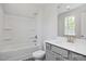 Bright bathroom featuring a shower-tub combo with modern fixtures and gray vanity at 98 Priming Way, Angier, NC 27501
