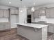 Modern kitchen featuring a large island with pendant lights, gray cabinets and stainless steel appliances at 98 Priming Way, Angier, NC 27501