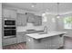 Beautiful kitchen showcasing stainless steel appliances, gray cabinetry, a large island, and stylish pendant lighting at 98 Priming Way, Angier, NC 27501