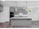 Spacious kitchen featuring gray cabinets, stainless steel appliances, and a central island with pendant lighting at 98 Priming Way, Angier, NC 27501