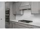 A close up of the kitchen featuring stainless steel appliances and gray shaker cabinets at 98 Priming Way, Angier, NC 27501