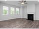 Spacious living room with large windows, ceiling fan, and a cozy fireplace at 98 Priming Way, Angier, NC 27501