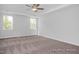 Spacious bedroom featuring a ceiling fan, tray ceiling, and ample natural light from multiple windows at 98 Priming Way, Angier, NC 27501