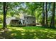 Expansive backyard with lush greenery, a wooden deck and a detached garage or shed at 1006 Apache Ln, Apex, NC 27502