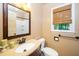 Cozy bathroom with granite countertop, wooden framed mirror, toilet, and window with blinds at 1006 Apache Ln, Apex, NC 27502