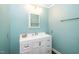 Bright bathroom with blue walls, white vanity with storage, sink, and chrome fixtures at 1006 Apache Ln, Apex, NC 27502