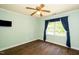 Bright bedroom with hardwood floors, ceiling fan, large window, and light green walls at 1006 Apache Ln, Apex, NC 27502