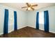 Bedroom with hardwood floors, ceiling fan, light blue walls, and windows with curtains at 1006 Apache Ln, Apex, NC 27502