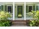 Close up of the front porch with white pillars, brick steps, and a decorative glass door at 1006 Apache Ln, Apex, NC 27502