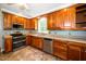 Traditional kitchen featuring wooden cabinets, stainless steel appliances, and a window view at 1006 Apache Ln, Apex, NC 27502