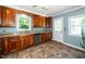 Functional kitchen with wood cabinets, tile flooring, and ample counter space near the door at 1006 Apache Ln, Apex, NC 27502