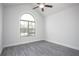 Bright bedroom featuring a vaulted ceiling, ceiling fan, large arched window, and gray wood-look flooring at 1041 Bonanza Ln # 37, Mebane, NC 27302