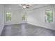 Bright bedroom showcasing new flooring, a tray ceiling with fan, and three large windows for natural light at 1041 Bonanza Ln # 37, Mebane, NC 27302