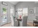 Bright dining area with a round wooden table, white chairs, and a view of the outdoor patio at 105 Bridgegate Dr, Cary, NC 27519