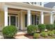 Inviting front porch featuring well-maintained landscaping, white columns, and decorative door at 105 Bridgegate Dr, Cary, NC 27519